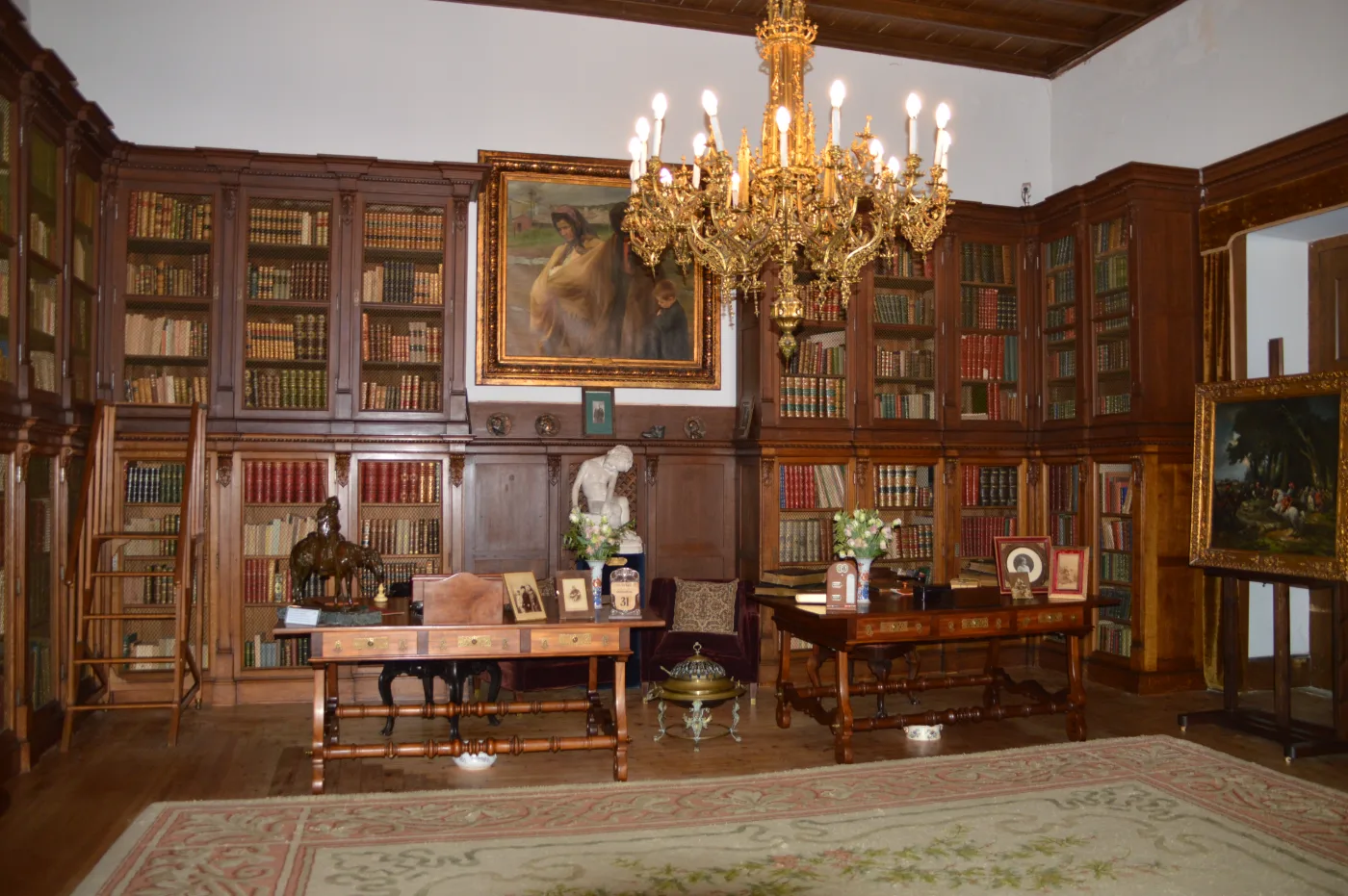Biblioteca da Casa dos Patudos, que servia de escritório a José Relvas, com estantes de livros, secretárias e jarras com flores frescas